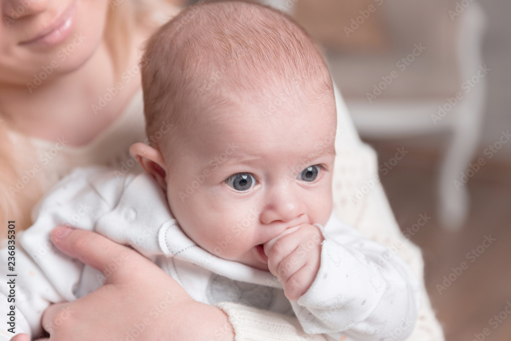 mother with baby sitting near the fireplace in a cozy living room