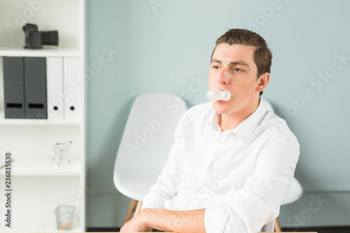 Obraz na plátně Joke, humor, office, people concept - man chewing the gum while he is working, g