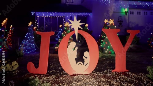 Joy christmas sign in front of house with lights