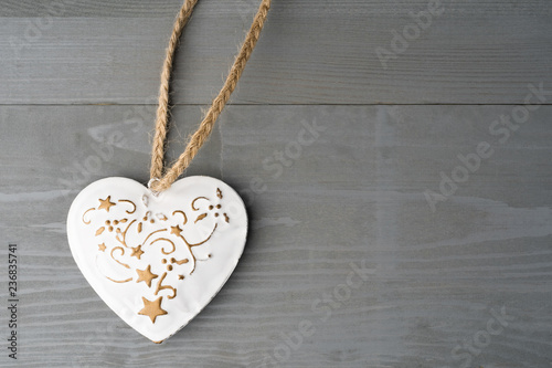 Festive heart shaped Christmas or New Year ornament with twine. Grey background. Copy space on the right.