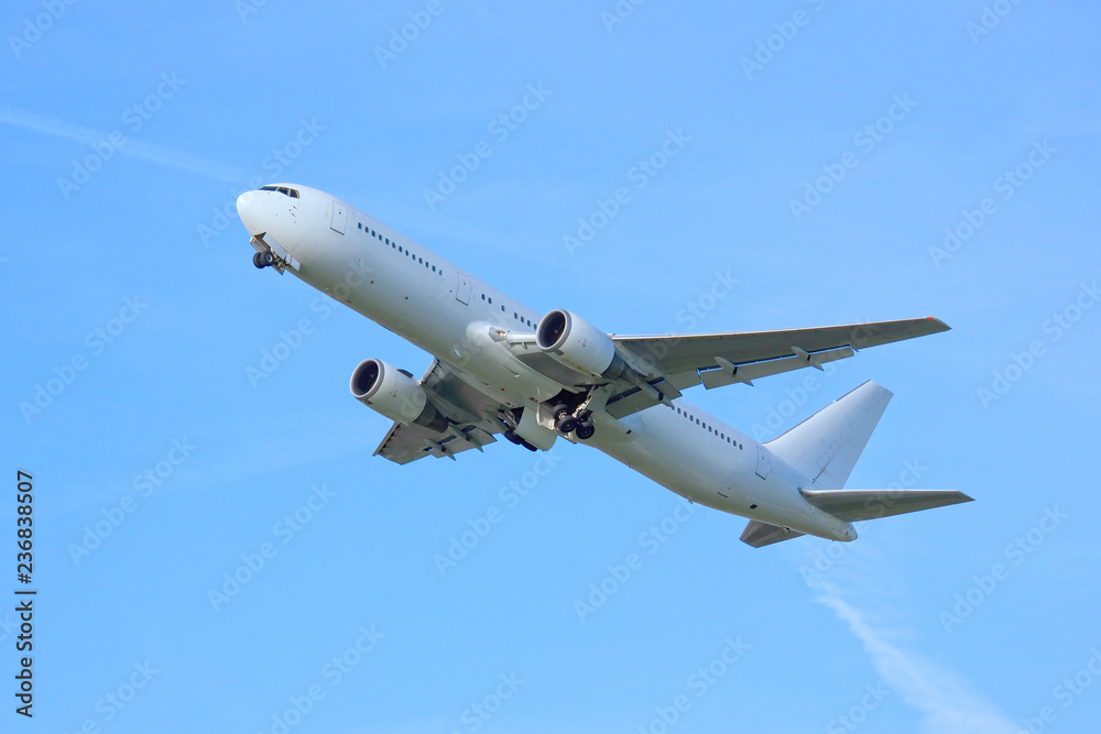 white airplaine 767 airborne take off into blue skies