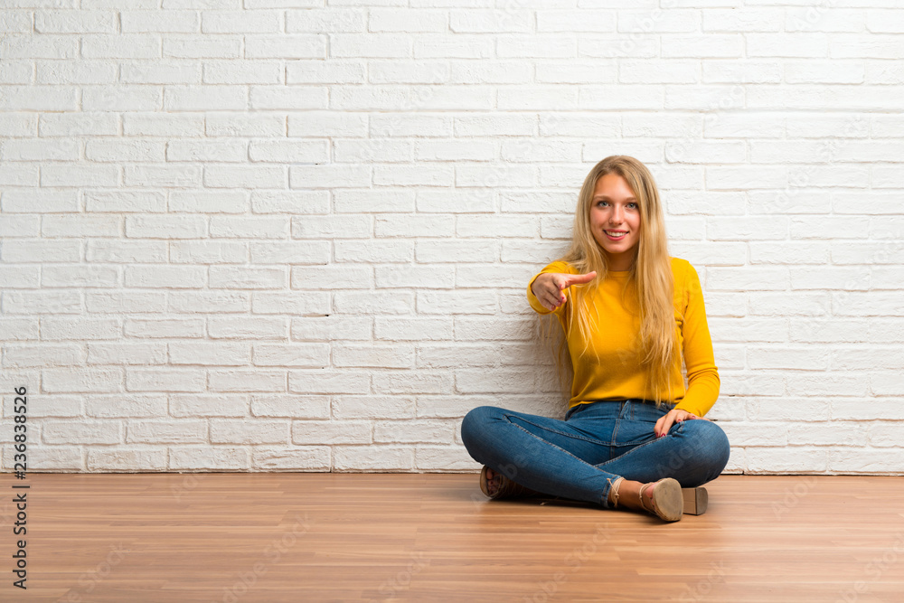 Young girl sitting on the floor shaking hands for closing a good deal Young girl sitting on the floor shaking hands for closing a good deal