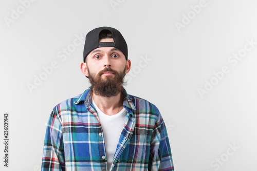 Beauty, fashion and people concept - Portrait of a young bearded hipster stylish guy over white background with copy space © satura_