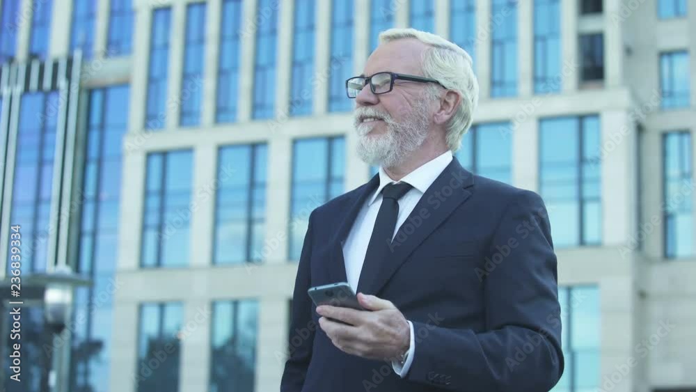 Inspired man in formal suit reading good news from stock market app for business Inspired man in formal suit reading good news from stock market app for business