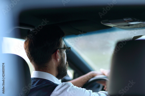 rear view.business man sitting in a modern car