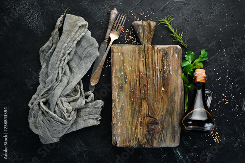 Wooden kitchen board and vegetables. On a black background. Free copy space.
