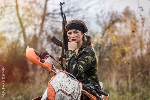 Young woman in camouflage clothes with gun