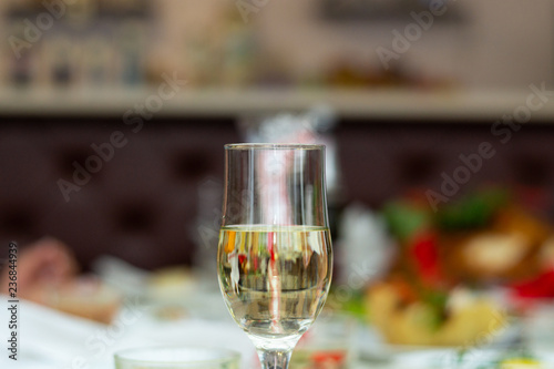 Glass with bubbly champagne in weddind. Wedding details in close-up view.
