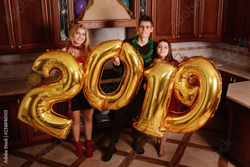 Obraz na płótnie New 2019 Year is coming. Group of cheerful young people carrying gold colored numbers and have fun at the party w salonie