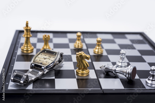 Chess Board isolated on white background. Golden and silver figures with hand watch