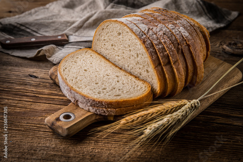 Fotobehang Sliced loaf of bread on a chopping board.