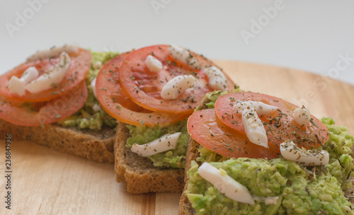 Close up of tomato avocado toast. Healthy eating, healthy breakfast, diet food concept. Front view