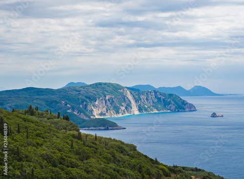 View on cllifs, forest and green hill and turquoise blue sea at Paleokastritsa bay, summer cloudy sky, Corfu, Kerkyra, Greece © Kristyna