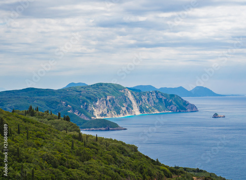 View on cllifs  forest and green hill and turquoise blue sea at Paleokastritsa bay  summer cloudy sky  Corfu  Kerkyra  Greece