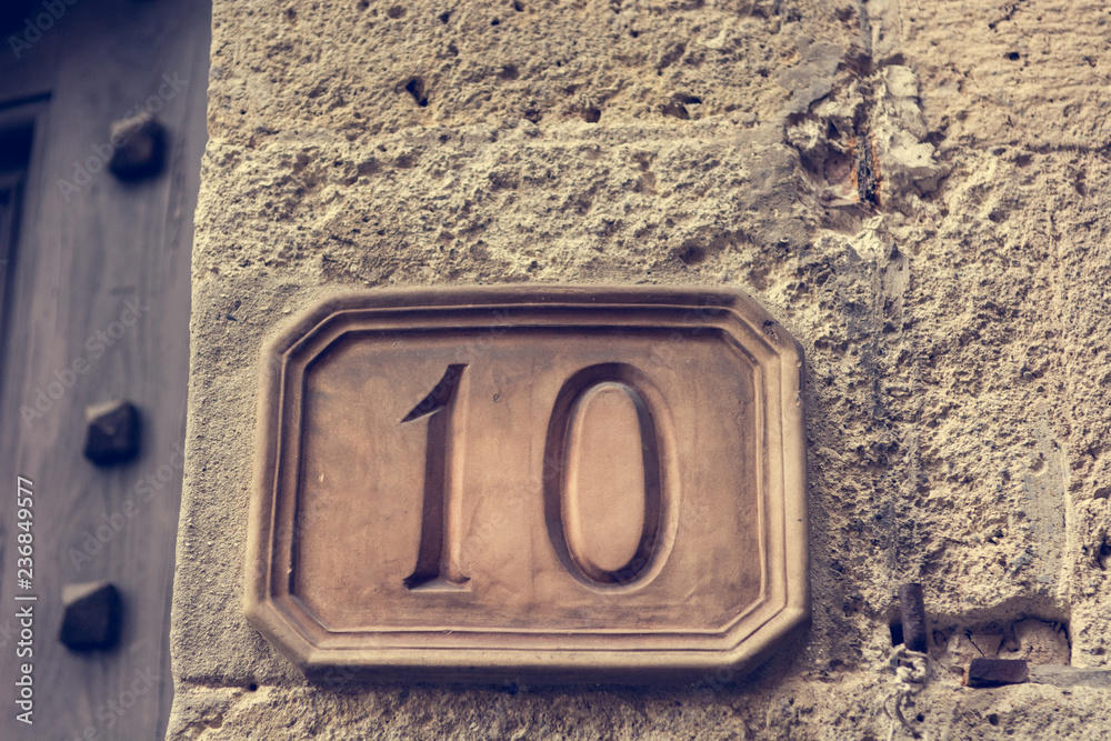 House number carved into clay tablet on facade. House number carved into clay tablet on facade.