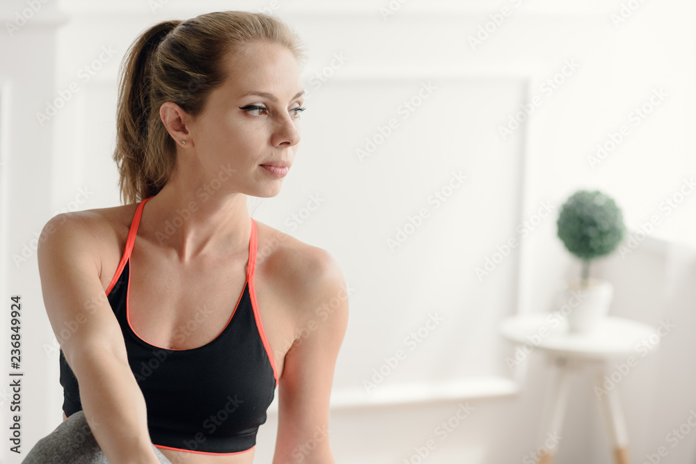 Portrait of young minded woman in sportswear resting after training