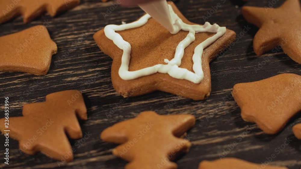 Decoration process of Christmas cookies. Close up garnishing homemade gingerbread star. Family culinary and traditions concept Decoration process of Christmas cookies. Close up garnishing homemade gingerbread star. Family culinary and traditions concept
