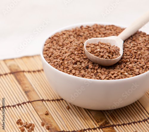 Buckwheat in a white bowl on a wooden table.