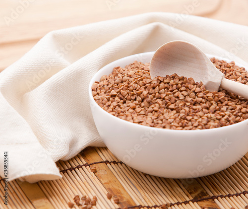 Buckwheat in a white bowl on a wooden table.