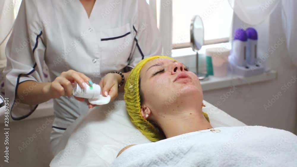 The esthetician applied the serum to the face of a beautiful girl. Hydration of the skin.Beautiful girl in a beauty salon. The beautician puts the cream on the girl's face. The esthetician applied the serum to the face of a beautiful girl. Hydration of the skin.Beautiful girl in a beauty salon. The beautician puts the cream on the girl's face.