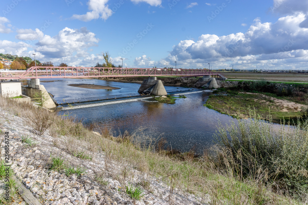 Steel road bridge crossing the Sorraia River which flows into the Tagus River. View from the sandy beach and boardwalk.Portugal, Ribatejo Region, Santarem, Coruche