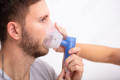Doctor Holding Oxygen Mask Over Patient's Mouth