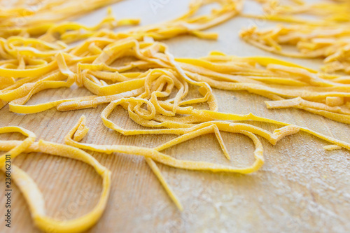 (selective focus) Fresh pasta called 'Fettuccine' made from fresh eggs and durum wheat flour. Fettuccine is a flat thick pasta popular in Roman and Tuscan cuisine.