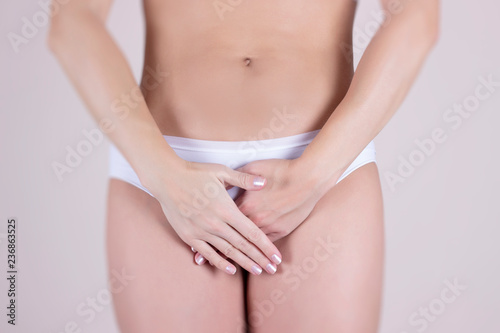 Woman in white panties holding her crotch