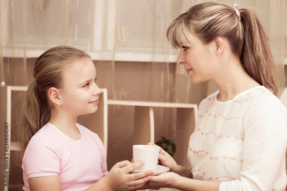 Loving daughter treating her mother to a mug of coffee Loving daughter treating her mother to a mug of coffee