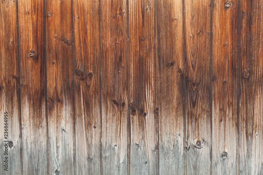 Naklejka premium Wooden Board background of dark burnt color with gradient in light color. Wooden planks for Your text. Knots on the wooden surface. Vertical strips of natural material in interiors and exteriors.