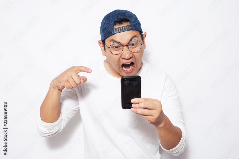 Young Man Texting Reading Chatting on His Phone, Angry Expression Young Man Texting Reading Chatting on His Phone, Angry Expression