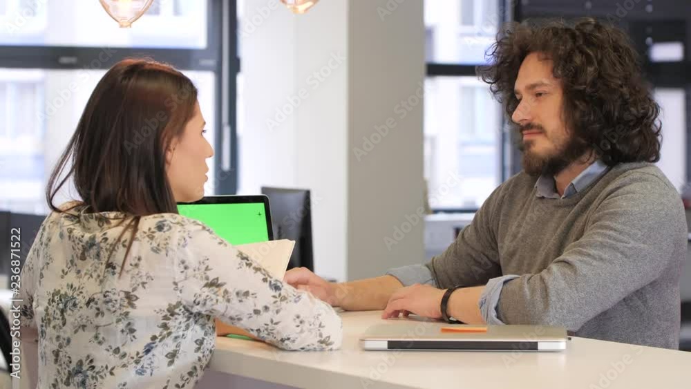 Startup young workers sitting and talking at the table with a laptop computer. Chroma Key Startup young workers sitting and talking at the table with a laptop computer. Chroma Key