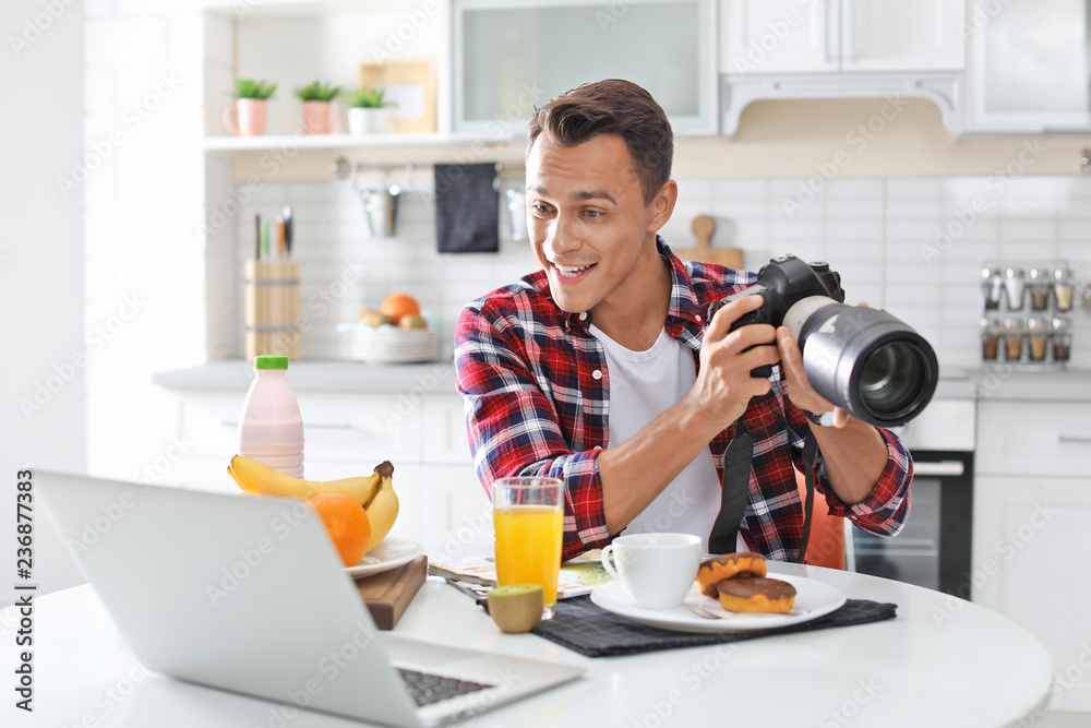 Portrait of food blogger with laptop and camera in kitchen. Online broadcast Portrait of food blogger with laptop and camera in kitchen. Online broadcast