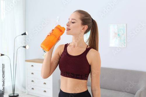 Woman drinking protein shake in living room