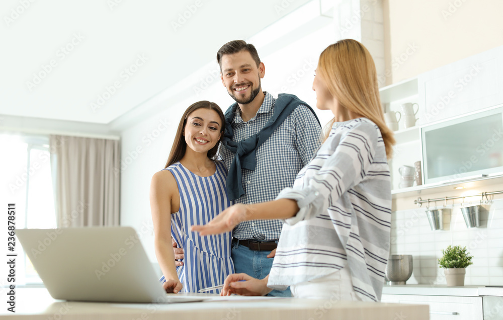 Female real estate agent working with couple, indoors Female real estate agent working with couple, indoors