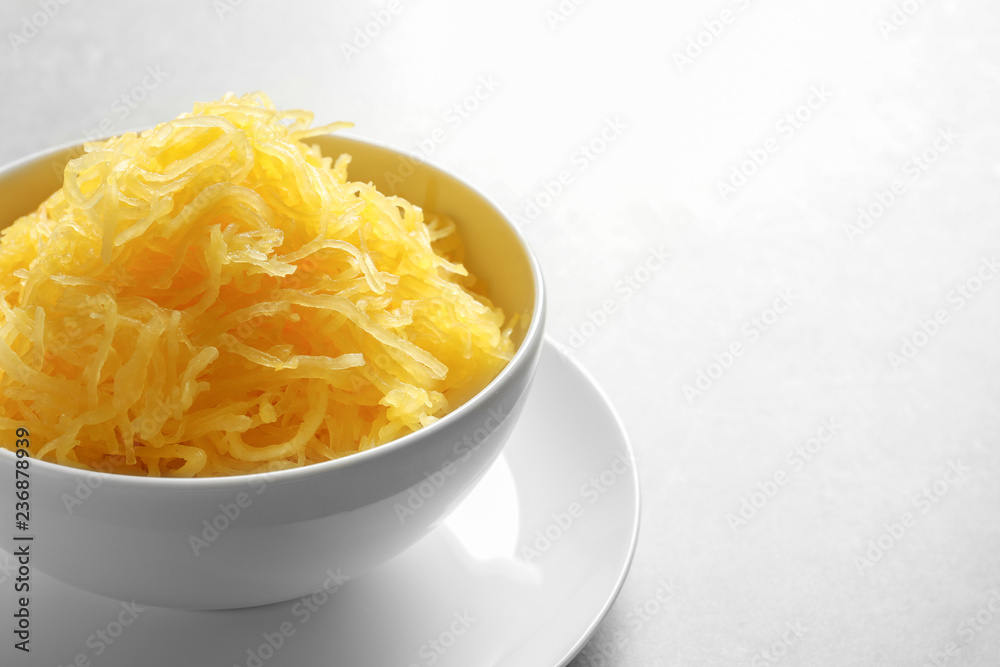 Bowl with cooked spaghetti squash on grey background. Space for text Bowl with cooked spaghetti squash on grey background. Space for text