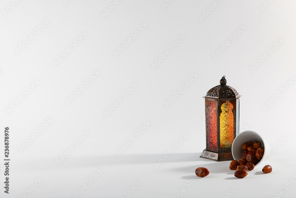 Fototapeta premium Muslim lamp and dates on white background. Space for text