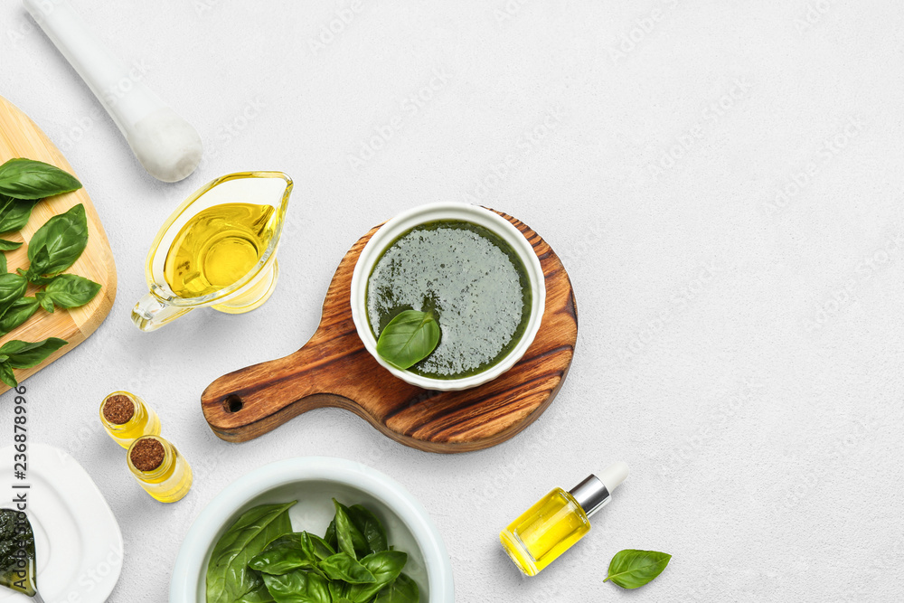 Composition with basil oil and leaves on white table. Space for text Composition with basil oil and leaves on white table. Space for text