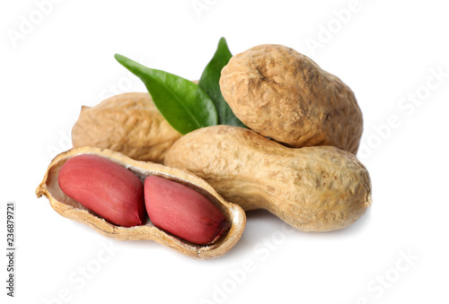Raw peanuts and leaves on white background. Healthy snack