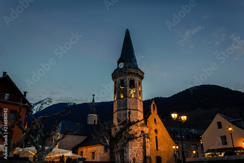 Iglesia situada en un pueblo entre montañas al anochecer en invierno