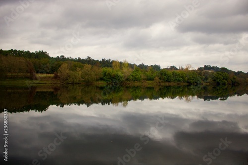 Vista do Rio Minho espelhado com reflexo da outra margem, num dia de outono. photo