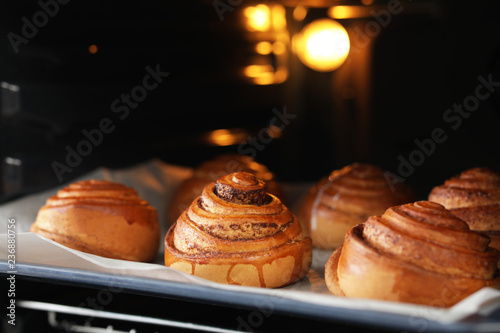 Tray with freshly baked buns in oven, closeup