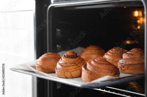 Open oven with tray of freshly baked buns, closeup