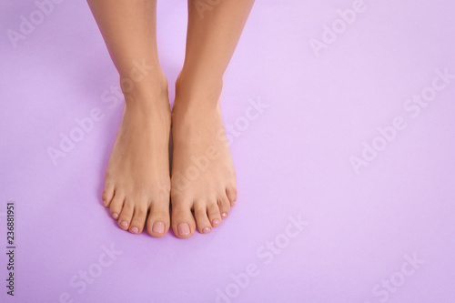 Fototapeta Naklejka Na Ścianę i Meble -  Woman with beautiful feet on color background, top view with space for text. Spa treatment