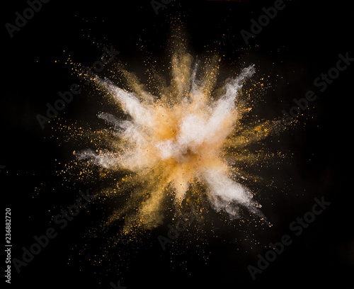 Silver and gold powder explosion on black background.