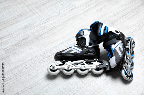 Inline roller skates on floor indoors. Space for text