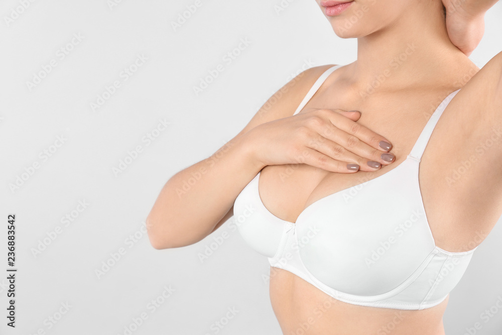 Woman checking her breast on white background, closeup. Space for text