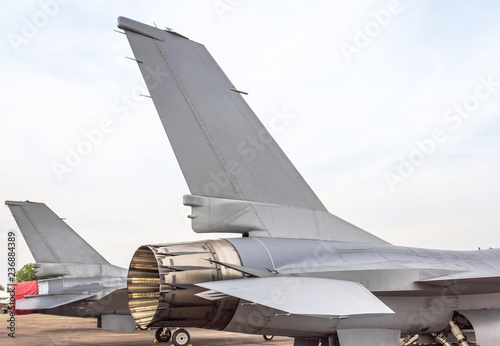 Close up exhaust and tail fin side of fighting military fighter jet aircraft parked on runway in the base airforce standby to take off  photo