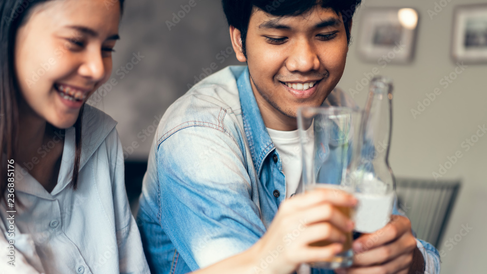 Friends are smiling, happy partying in the bar and talking and clinking bottles with beverages. Friends are smiling, happy partying in the bar and talking and clinking bottles with beverages.