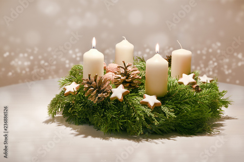 Second Advent - decorated Advent wreath from fir and evergreen branches with white burning candles, tradition in the time before Christmas, warm background with festive bokeh and copy space photo
